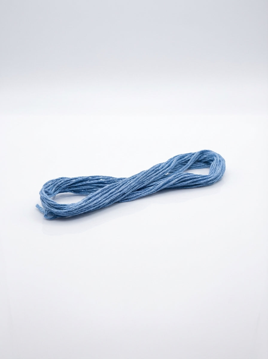Studio shot of a baby blue cotton embroidery floss skein, showcasing its soft texture and color.