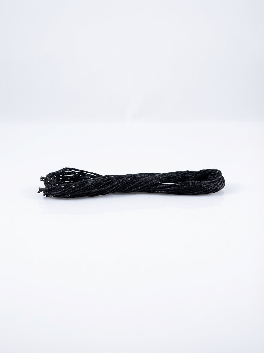 Black cotton embroidery floss skein for cross-stitch and sewing; soft texture, matte finish.