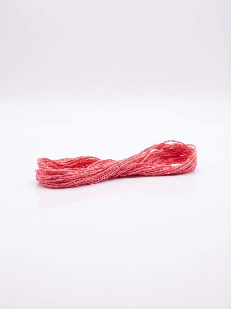 Studio shot of light carnation pink cotton embroidery floss skein, showcasing its soft texture and vibrant color.