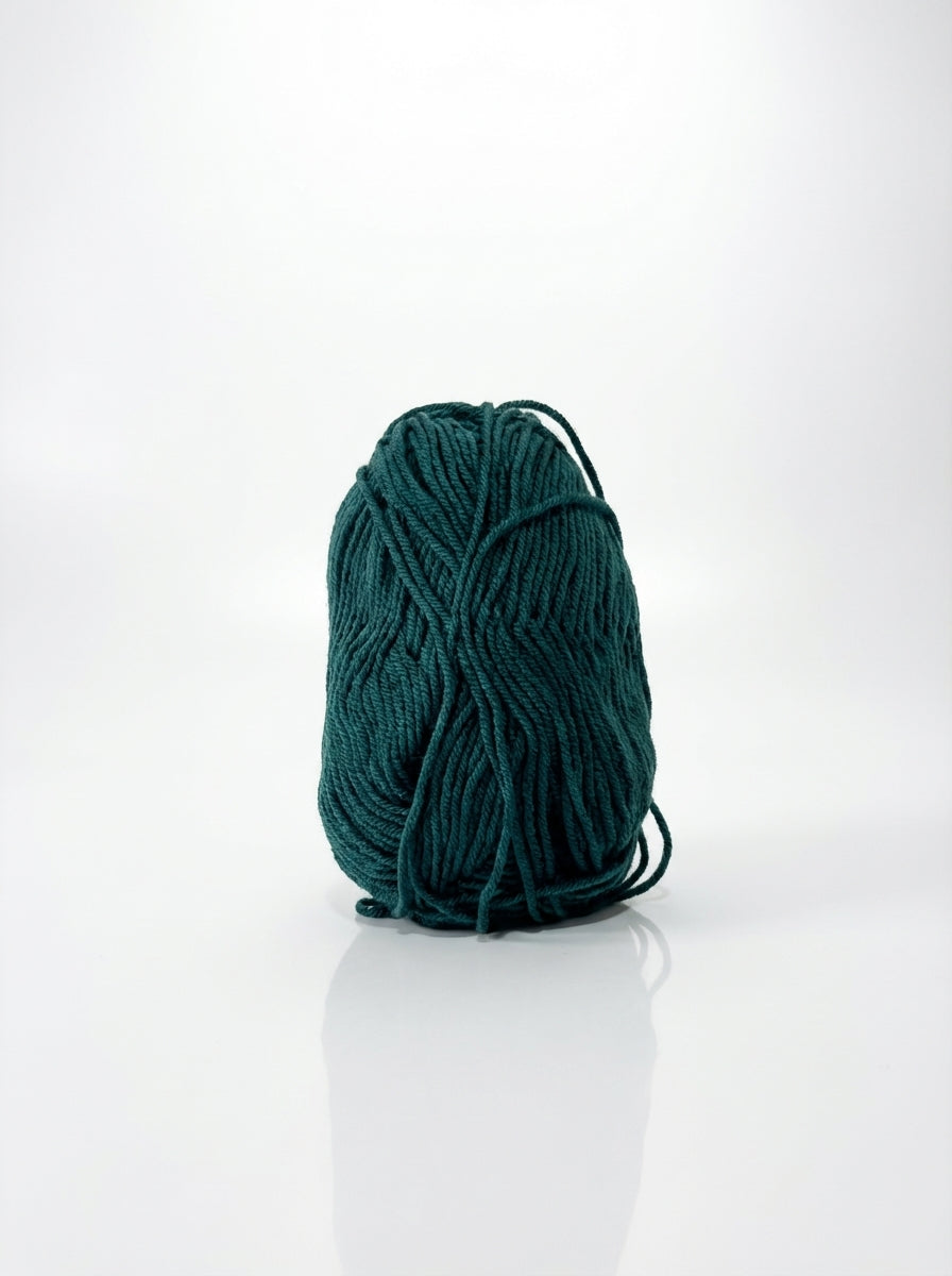 Studio shot of peacock green cotton yarn ball, showcasing its texture and vibrant color, suitable for crafting.