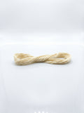 Close-up of a cream cotton embroidery floss skein showing texture and smooth matte finish.