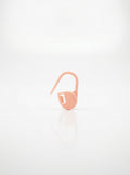 Light pink crochet latch clip hook for marking stitches, smooth plastic finish, close-up studio shot.