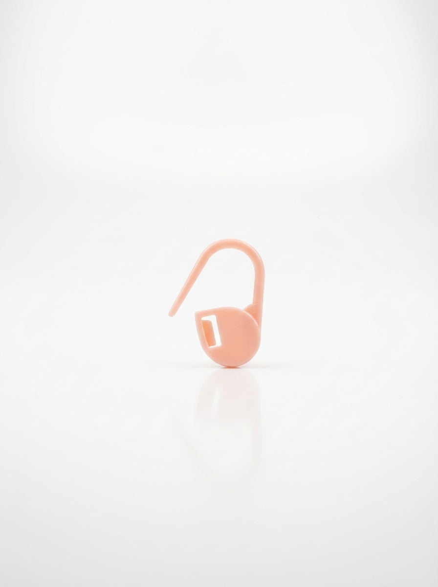 Light pink crochet latch clip hook for marking stitches, smooth plastic finish, close-up studio shot.