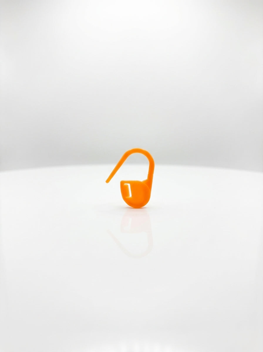 Orange plastic crochet latch clip hook for marking stitches, close-up studio shot, bright and clear.