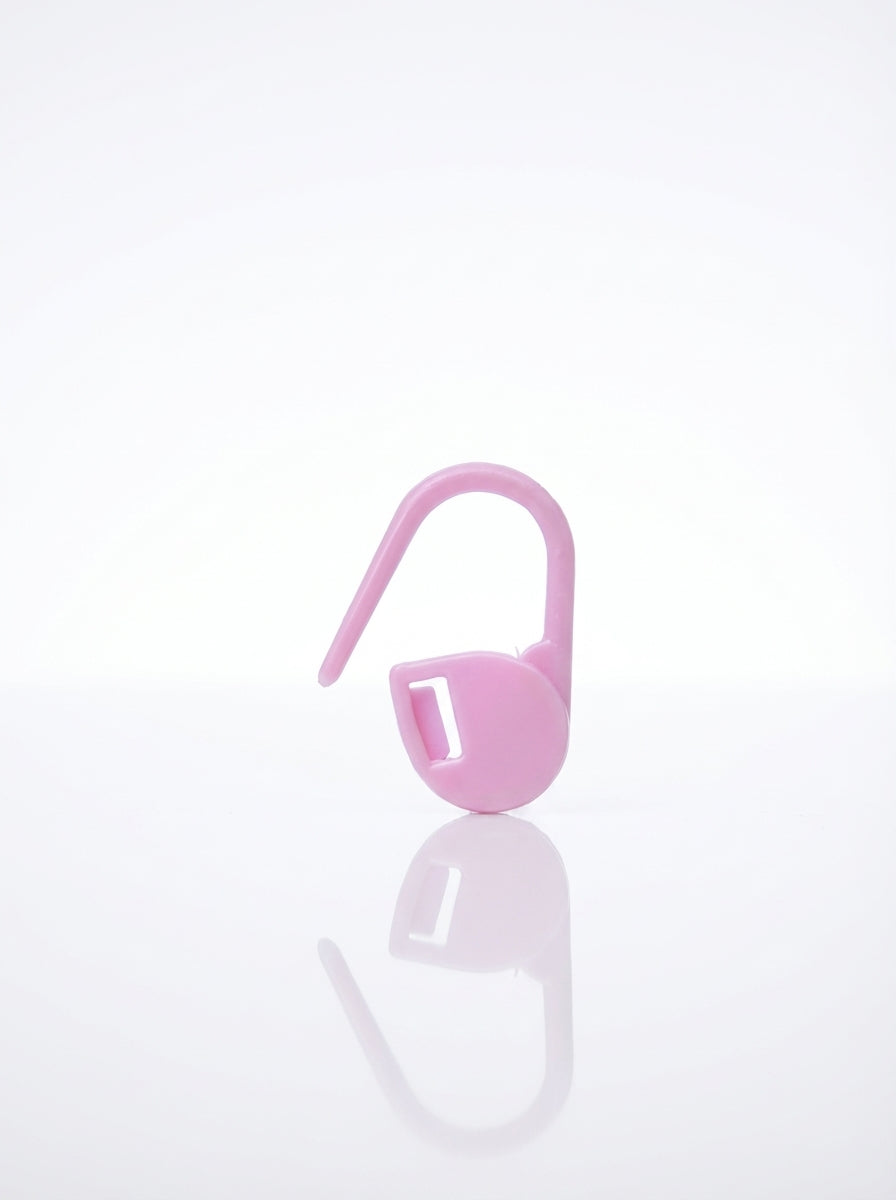 Pink plastic crochet stitch marker, close-up studio shot showing smooth, shiny finish and clip detail.