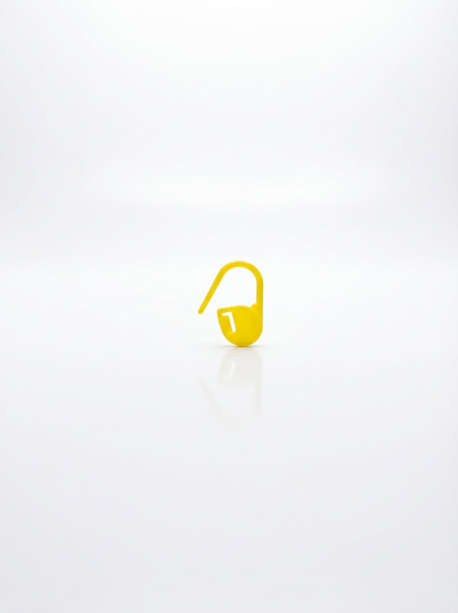 Yellow plastic crochet stitch marker for marking stitches in knitting and crochet projects.