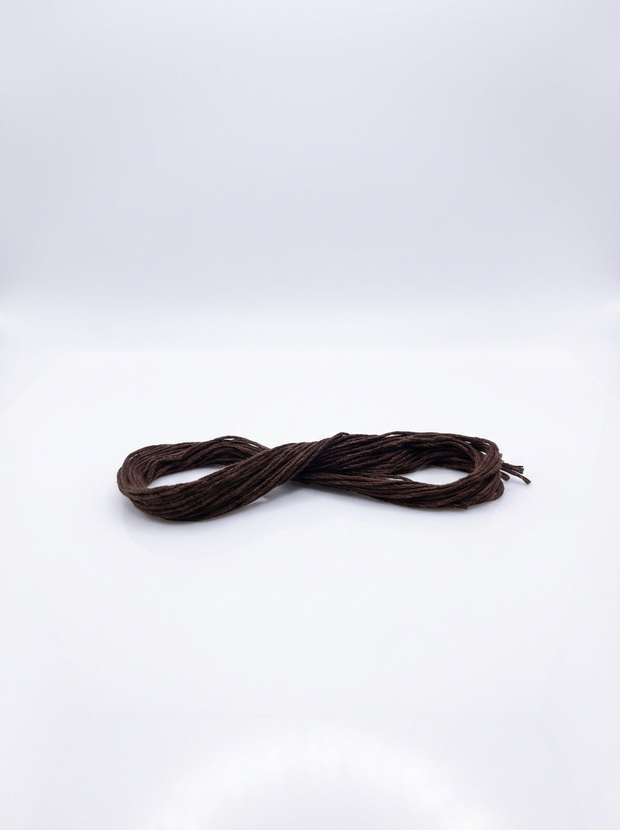 Studio shot of dark coffee brown cotton embroidery floss skein, showcasing its texture and rich color.