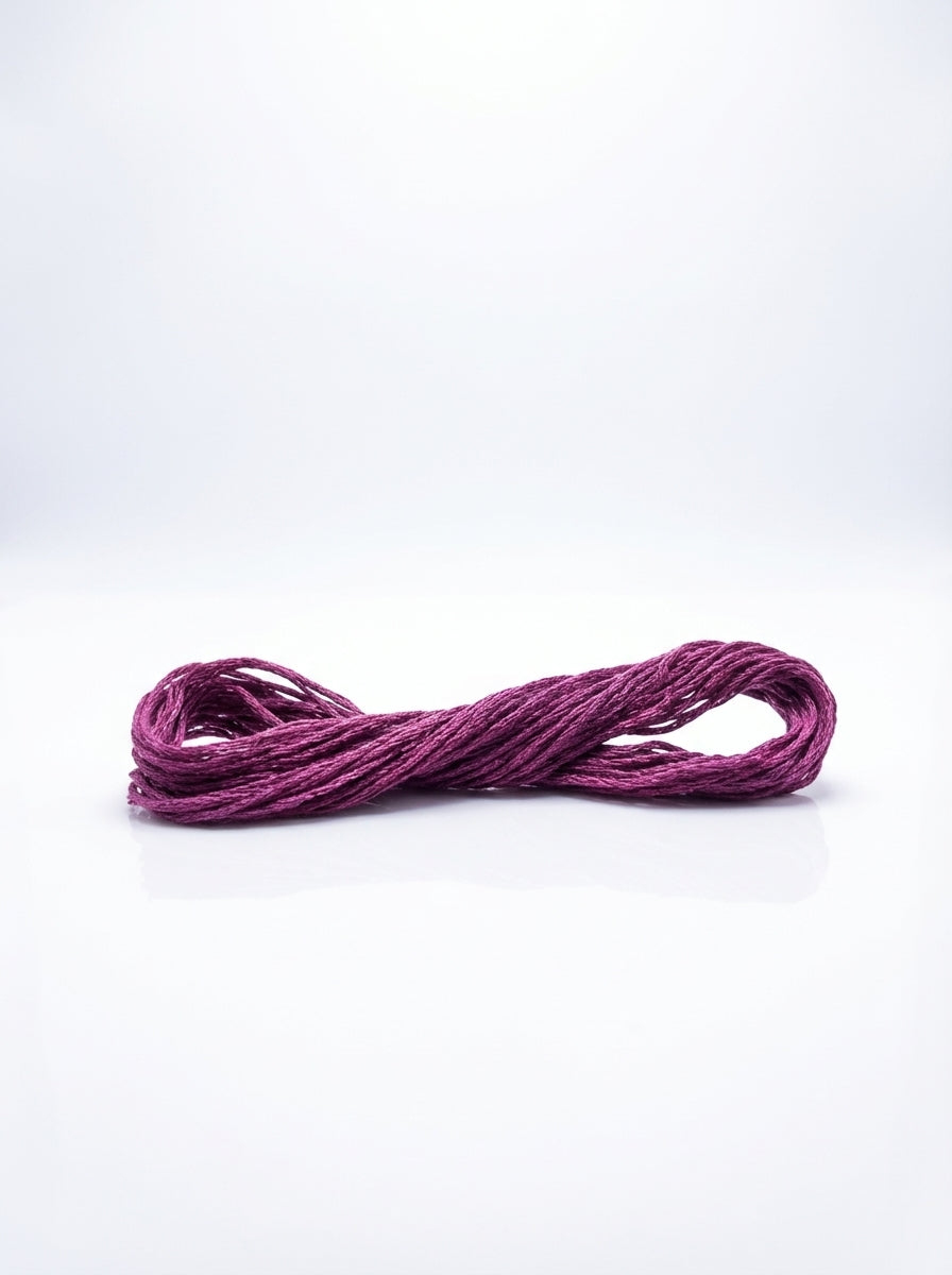 Dark grape colored cotton embroidery floss skein, tightly wound and ready for crafting projects.