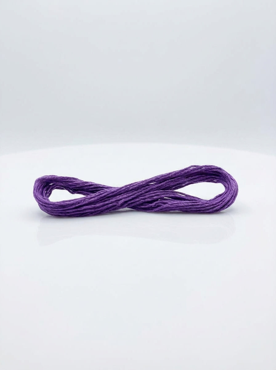 Studio shot of a dark lavender cotton embroidery floss skein, showcasing its color and texture.