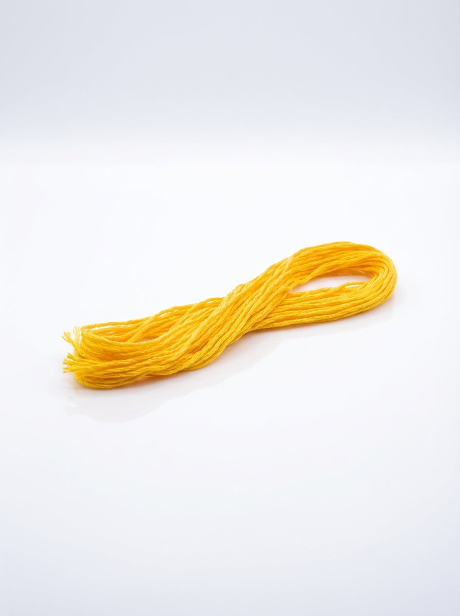 Studio shot of dark lemon yellow embroidery floss skein, showcasing its bright color and cotton texture