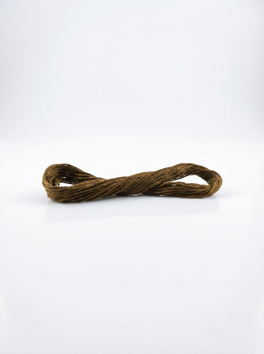 Close-up of a dark golden olive embroidery floss skein showing the cotton texture and gentle sheen.