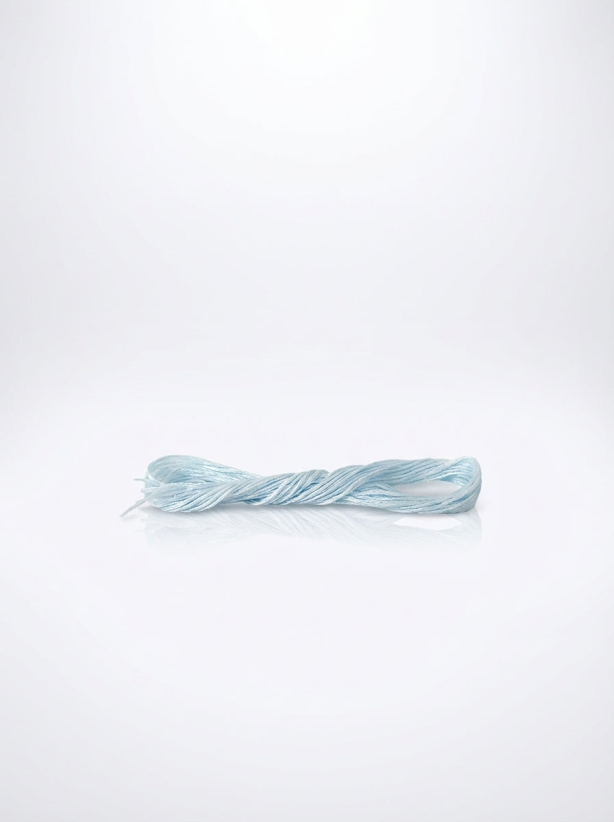Studio shot of light antique blue cotton embroidery floss skein, showcasing its twisted texture and soft color.