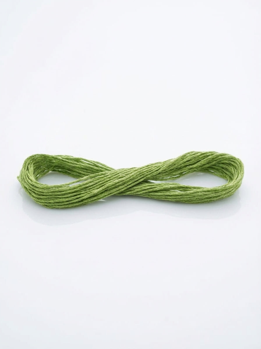 Skein of forest green cotton embroidery floss, neatly bundled, showing matte texture and rich color.